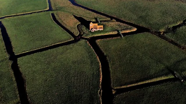 A view of St Thomas Becket church during the morning sunshine in Fairfield near Ashford, Tuesday November 2, 2021. The tiny building dates back to the late 12th century and sits isolated in a field cut through with dykes and grazed by sheep on the Romney Marsh in Kent. (Photo by Gareth Fuller/PA Wire via AP Photo)