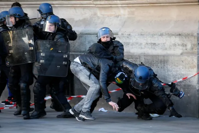 Police officers apprehend a protester during clashes at a demonstration against alleged police abuse, in Paris Saturday, February 18, 2017. Anti-racism groups and other activists are gathered in Paris in support of victims of police violence, after a young black man was allegedly raped with a police baton in an incident that prompted violent protests in impoverished suburbs. (Photo by Francois Mori/AP Photo)