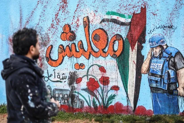 Syrian graffiti artist Aziz Esmer paints the Al Jazeera correspondent Vail ed-Dahduh, who lost his son Hamza in Israeli attacks on Gaza, and the Palestinian flag on a school wall to show solidarity in Idlib, Syria on January 10, 2024. (Photo by Izettin Kasim/Anadolu via Getty Images)