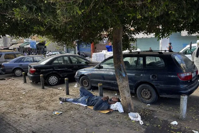 A homeless man sleeps on the ground in Beirut, Lebanon, Saturday, October 16, 2021. (Photo by Bilal Hussein/AP Photo)