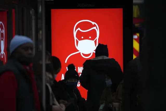 A government digital poster encouraging people to wear face masks to curb the spread of coronavirus, is displayed in a bus stop in London, Friday, December 17, 2021. After the U.K. recorded its highest number of confirmed new COVID-19 infections since the pandemic began, France announced Thursday that it would tighten entry rules for those coming from Britain. Hours later, the country set another record, with a further 88,376 confirmed COVID-19 cases reported Thursday, almost 10,000 more than the day before. (Photo by Matt Dunham/AP Photo)