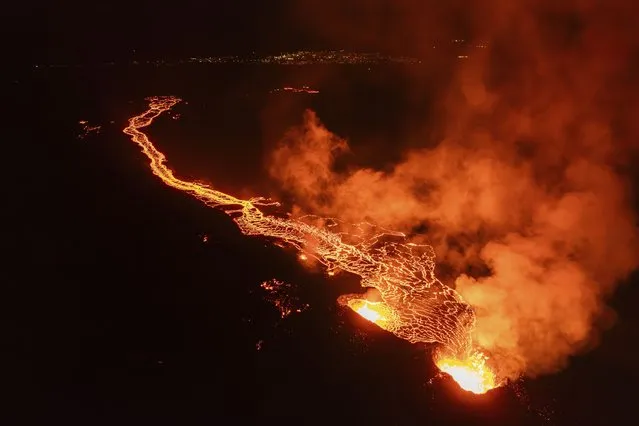 Lava flows from the volcano, near the town of Grindavik, Iceland, early Monday, March 25, 2024. The volcano in southwestern Iceland that erupted three times in December, January and February, sending lava towards a nearby community, keeps erupting. (Photo by Marco di Marco/AP Photo)