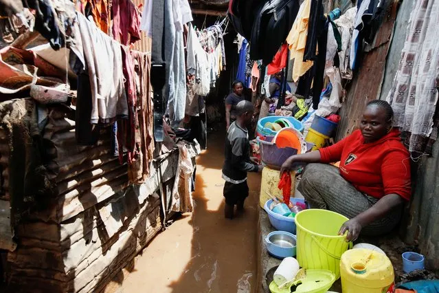 Juliet Akoth sits next to her belongings recovered from her flooded house after the Nairobi river burst its banks within the Mathare valley settlement in Nairobi, Kenya on April 24, 2024. (Photo by Monicah Mwangi/Reuters)