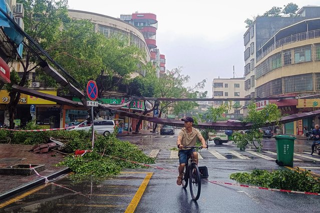 A man rides along a road following heavy rains in Qingyuan city, in China's southern Guangdong province on April 22, 2024. Heavy rain has descended upon the vast southern province of Guangdong in recent days, swelling rivers and raising fears of severe flooding that state media said could be of the sort only “seen around once a century”. (Photo by AFP Photo/China Stringer Network)