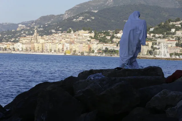 A migrant walks at the Franco-Italian border in Ventimiglia, Italy, Wednesday, June 17, 2015. Some 100 migrants, principally from Eritrea and Sudan, have attempted since last Friday, to cross the border from Italy into France but have been blocked by French and Italian police. (AP Photo/Lionel Cironneau)