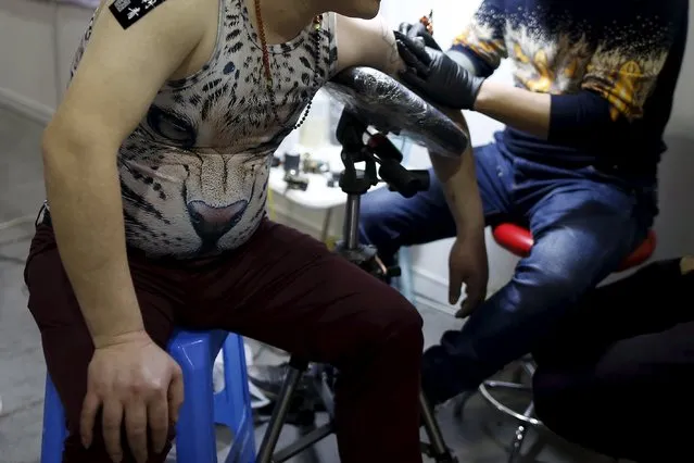 A man gets tattooed during an exhibition of 2016 Shanghai International Art Festival Of Tattoos in Shanghai, China, April 23, 2016. (Photo by Aly Song/Reuters)