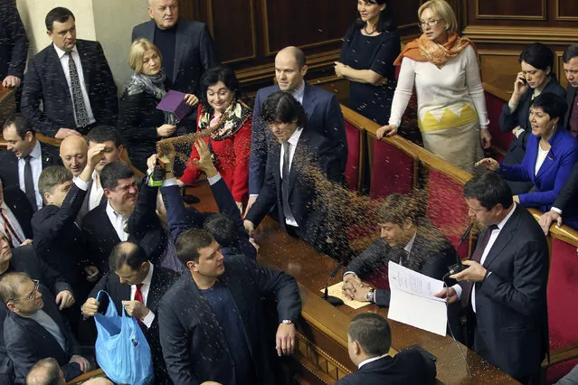 Opposition deputies throw buckwheat at newly elected deputy Viktor Pylypyshyn (R) as he takes the oath in Ukrainian Parliament in Kiev January 15, 2014. Opposition deputies from the Svoboda (Freedom) Ukrainian nationalist party blame Pylypyshyn for what they said were unfair elections. In Ukraine, buckwheat is a symbol of bribing voters. (Photo by Valentyn Ogirenko/Reuters)