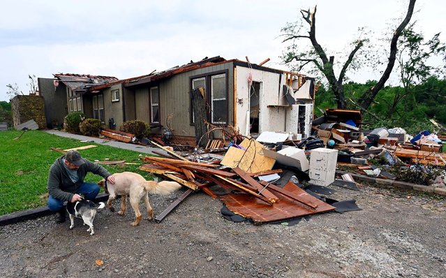 Ryan Whitten pets his two dogs after looking at his damaged home after severe weather and tornados hit the area in Columbia, Tennessee, U.S., May 9, 2024. Whitten is missing his third dog named, Dash, and two cats. (Photo by Mark Zaleski/The Tennessean/USA TODAY Network via Reuters)