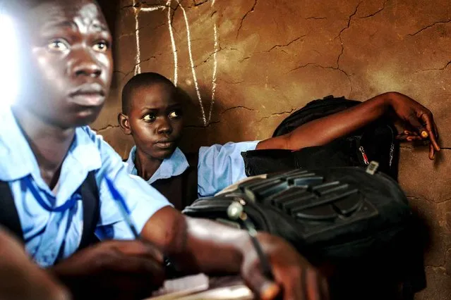 Students take notes during an English language class at the Juba Nabari Primary School, in Juba on April 9, 2014. Recent conflict in the country has made resources scarce, many civil servants, including teachers, have not received their pay for several months. (Photo by Andrei Pungovschi/AFP Photo)