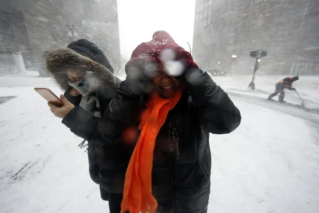 People walk in the wind-driven snow during a winter storm Tuesday, March 14, 2017, in Boston. (Photo by Michael Dwyer/AP Photo)