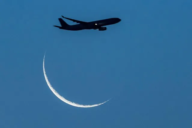 A plane is seen flying across the the crescent Moon over Sydney, Australia, on 04th January 2022. (Photo by Izhar Ahmed Khan/Alamy Live News)