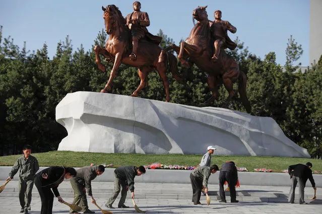 People sweep in front of statues of former North Korean leaders Kim Il Sung and Kim Jong Il in central Pyongyang, North Korea April 12, 2017. (Photo by Damir Sagolj/Reuters)