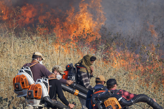 Israeli firefighters put out flames in a field after rockets launched from southern Lebanon landed on the outskirts of Katzrin in the Israel-annexed Golan Heights on June 2, 2024. Since the outbreak of war between the Palestinian militant group Hamas and Israel on October 7, the Lebanese-Israeli border area has witnessed near-daily exchanges of fire, mainly between the Israeli army and Hamas ally Hezbollah. (Photo by Jalaa Marey/AFP Photo)