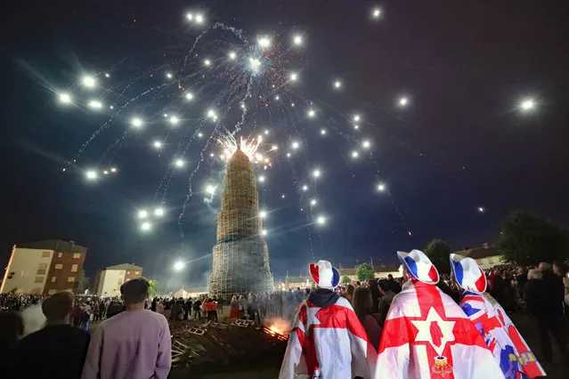 Crowds watch a fireworks display before the huge bonfire in the loyalist Corcrain area of Portadown, Co Armagh, , Northern Ireland is lit on the “Eleventh night” to usher in the Twelfth commemorations on Saturday, July 10, 2021. (Photo by Niall Carson/PA Images via Getty Images)