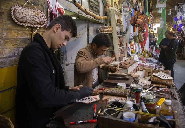 Iraqis engrave on leather in their shop inside Al Sarai antiques market in Baghdad, Iraq, Saturday, February 19, 2022. (Photo by Hadi Mizban/AP Photo)