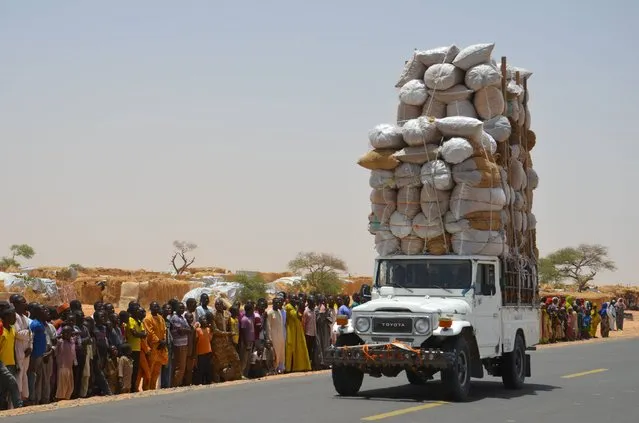 An overloaded car travels through the Assaga refugee camp in Diffa on May 17, 2016, close to the Niger-Nigeria border. Chief of Humanitarian Operations of the UN, Stephen O'Brien, vowed on May 17 to raise funds at the next World Humanitarian Summit for “significant” help to the more than 240,000 refugees displaced by Boko Haram in camps in south-east Niger. (Photo by Boureima Hama/AFP Photo)