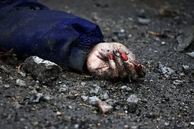 A body of a woman, who according to residents was killed by Russian army soldiers, lies on the street, amid Russia's invasion of Ukraine, in Bucha, in Kyiv region, Ukraine on April 2, 2022. (Photo by Zohra Bensemra/Reuters)