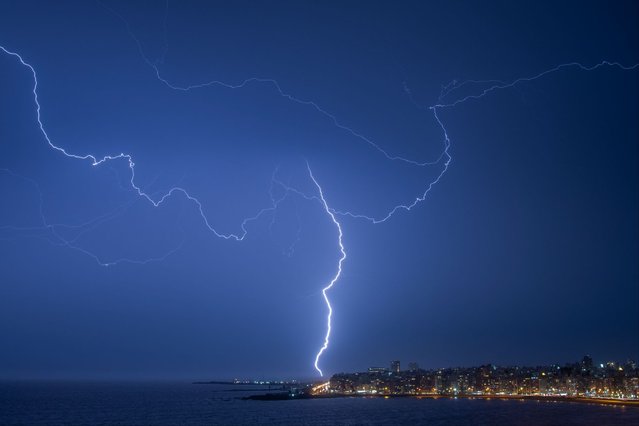 Lightning strikes during a thunderstorm in Montevideo on March 19, 2024. (Photo by Mariana Suarez/AFP Photo)