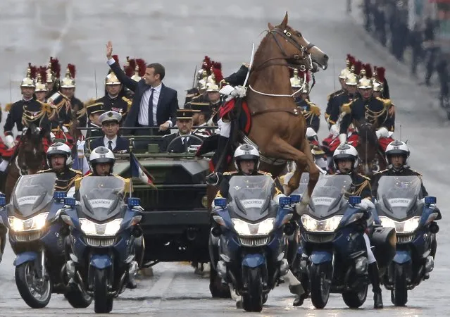 A horse rears as new French President Emmanuel Macron parades in a car on the Champs Elysees avenue after his formal inauguration ceremony as French President on May 14, 2017 in Paris. (Photo by Michel Euler/AFP Photo)