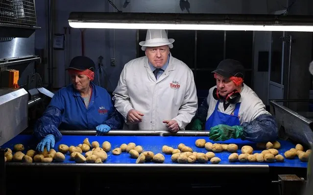 Britain's Prime Minister Boris Johnson (C) helps quality control workers during a general election campaign visit to the Tayto Castle crisp factory in County Armagh, Northern Ireland, on November 7, 2019. Britain's two main parties promised billions of pounds of investment for hospitals, schools and infrastructure on Thursday as they seek to woo voters weary of austerity ahead of the December 12 general election. (Photo by Daniel Leal-Olivas/AFP Photo/Pool)