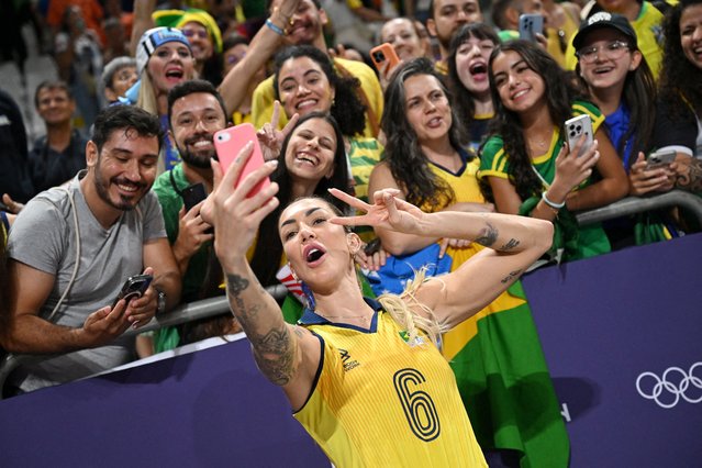 Thaisa Daher de Menezes #6 of Team Brazil takes a selfie with fans during the Women's Quarterfinal match between during the Women's Quarterfinal match between Team Brazil and Team Dominican Republic on day eleven of the Olympic Games Paris 2024 at Paris Arena on August 06, 2024 in Paris, France. (Photo by Annegret Hilse/Reuters)