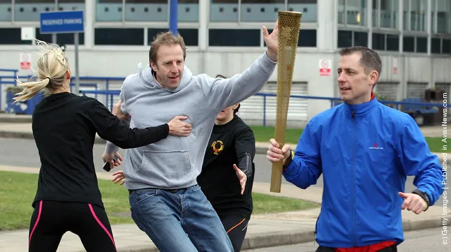 Men stage an attack during a training session for the Olympic Torch Security Team who will be protecting the torch bearers and Olympic flame during the torch relay's progress through the UK, at the Metropolitan Police Training School