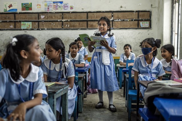 A student stands while reading her textbook in a classroom during the reopening of schools after a long halt due to the violence surrounding anti-government protests that resulted in the resignation of Sheikh Hasina at the Viqarunnisa Noon School and College in Dhaka on August 18, 2024. (Photo by Luis Tato/AFP Photo)