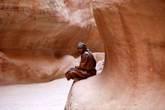 Bedouin young man sits in the Siq in the ancient city of Petra, south of Amman, Jordan, November 21, 2019. (Photo by Muhammad Hamed/Reuters)