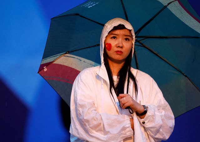 A spectator with an umbrella during the opening ceremon in Paris, France on July 26, 2024. (Photo by Piroschka Van De Wouw/Reuters)