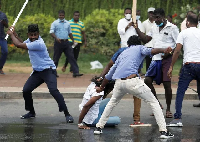 Supporters of Sri Lanka's ruling party hold down an anti-government demonstrator during a clash between the two groups, amid the country's economic crisis, in Colombo, Sri Lanka, May 9, 2022. (Photo by Dinuka Liyanawatte/Reuters)