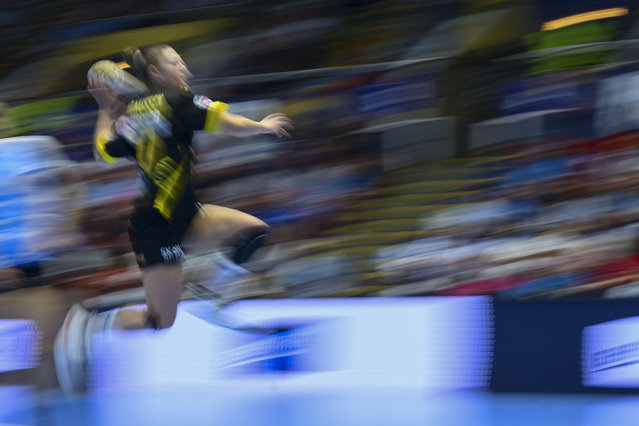 In this image taken with a slow shutter speed, Maja Magnussen of Nykobing Falster tries to score during the Champions League women's handball match between CSM Bucuresti and Denmark's Nykobing Falster, at the Polyvalent Hall in Bucharest, Romania, Sunday, October 6, 2024. (Photo by Raed Krishan/AP Photo)