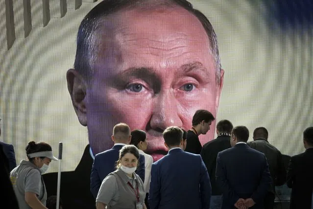Participants watch Russian President Vladimir Putin's addressing a plenary session of the St. Petersburg International Economic Forum in St.Petersburg, Russia, Friday, June 17, 2022. (Photo by Dmitri Lovetsky/AP Photo)