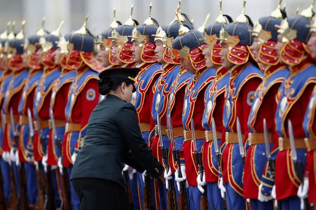 A member of the Mongolian army adjusts the uniforms of State Palace honor guards as they stand in line before a welcoming ceremony in Ulan Bator. (Photo by Carlos Barria/Reuters)