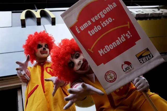Men dressed as “Ronald McDonald”, the McDonald's company mascot, take part in a protest against labor abuses and poor working conditions, in front of a McDonald's restaurant at Paulista avenue, in Sao Paulo, August 18, 2015. The poster reads “All of this it's a shame”. (Photo by Nacho Doce/Reuters)