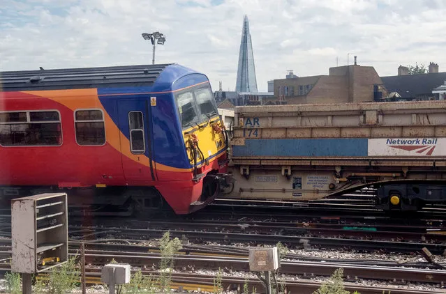 In this photo taken through a window, a train is seen derailed by Waterloo station in London, Tuesday, August 15, 2017. A train partly left the tracks early Tuesday morning as it was pulling away from a platform at low speed, Network Rail said. Three people were checked over by London Ambulance Service but nobody was hospitalized. (Photo by Victoria Jones/PA Wire)
