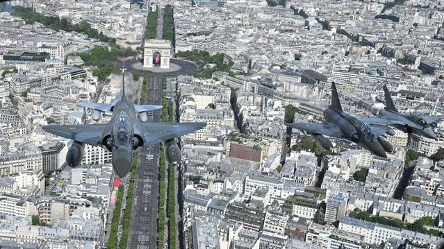 An aerial view shows Mirage 2000 fighter jets performing a fly-over during the Bastille Day military parade over the Champs-Elysees avenue in Paris on July 14, 2022. (Photo by Christophe Simon/AFP Photo)