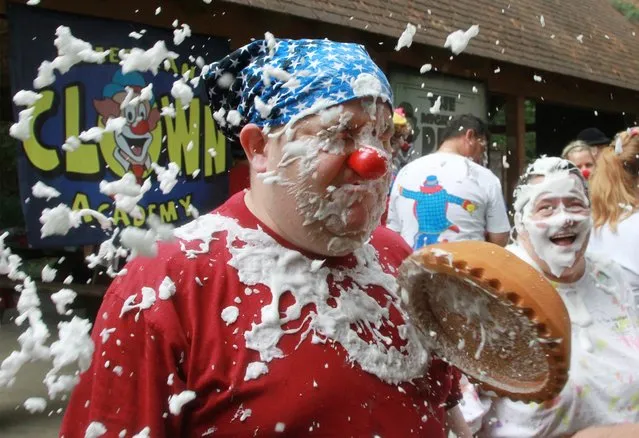 Matt Brodeur, of Fairhaven, Mass., also known by his clown name of “Dusty”, is pelted by a foam pie shell filled with soap at the American Clown Academy in Newark, Ohio, Wednesday, August 19, 2015. The students at the clown school were spending a week learning the traditions of the art of clowning, including learning a long kept circus formula for making soap for pie fights. (Photo by Paul M. Walsh/The Eau Claire Leader-Telegram via AP Photo)