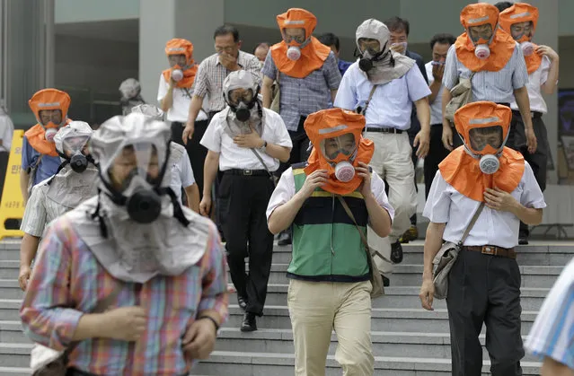 In this August 18, 2010, file photo, South Koreans wearing gas masks escape from a mock smoke attack during an anti-terror exercise carried out as part of Ulchi Freedom Guardian exercise, against possible attacks from North Korea in Seoul, South Korea. The Ulchi Freedom Guardian drills set to begin Monday, Aug. 21, 2017 will be the first joint military exercise between the allies since North Korea successfully flight-tested two intercontinental ballistic missiles in July and threatened to bracket Guam with intermediate range ballistic missile fire in August. (Photo by Lee Jin-man/AP Photo)