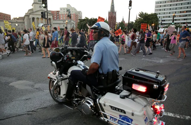 Demonstrators with Black Lives Matter march past a Metropolitan police officer blocking traffic during a protest in Washington, U.S., July 9, 2016. (Photo by Joshua Roberts/Reuters)