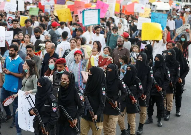 Female police officers escort women as a security measure as they attend the Aurat March (Women's March) in Karachi, Pakistan on March 8, 2020. (Photo by Akhtar Soomro/Reuters)