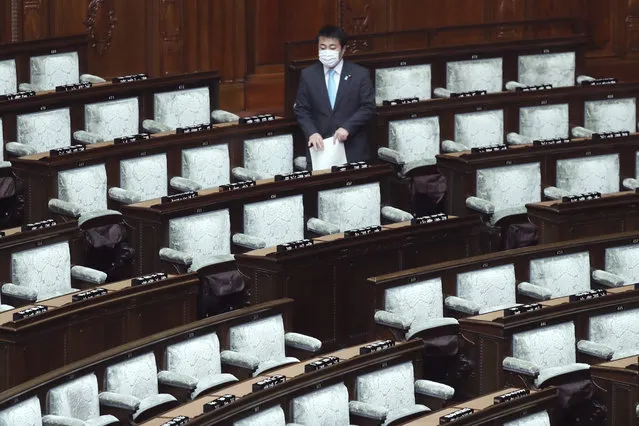 A lawmaker wearing face mask arrives for a plenary session at the Lower House in Tokyo, Thursday, March 12, 2020. Japan's lower house of parliament endorsed Thursday a legislation that will allow Prime Minister Shinzo Abe to declare state of emergency in handling the coronavirus outbreak. (Photo by Koji Sasahara/AP Photo)