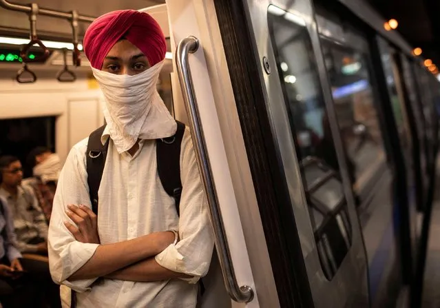 A commuter wears a handkerchief as a mask as he travels in a metro train, amid coronavirus disease (COVID-19) fears, in New Delhi, India, March 13, 2020. (Photo by Danish Siddiqui/Reuters)