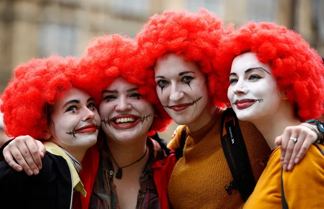 Demonstrators dressed as Ronald McDonald, the mascot of US burger chain McDonalds, pose for a photograph as they participate in a protest over working conditions and the use of zero- hour contracts at British outlets of US burger chain, in central London on September 4, 2017. McDonald' s staff have gone on strike for the first time in Britain in two of the chain' s outlets in a dispute over pay and conditions. (Photo by Tolga Akmen/AFP Photo)