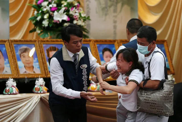 Family members of victims who died in the bus incident which killed passengers including tourists from China near Taoyuan International Airport, cry as they attend a funeral in Taoyuan, Taiwan July 21, 2016. (Photo by Tyrone Siu/Reuters)