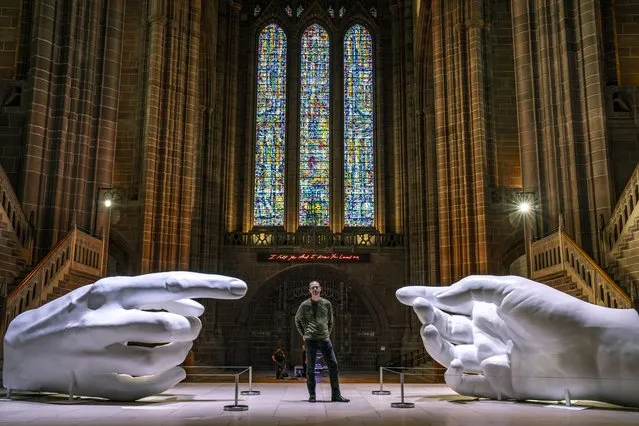 Artist Peter Walker with his work, Connection, a contemporary twist on Michelangelo's masterpiece the creation of Adam, part of his Being Human exhibition inside Liverpool Cathedral on Tuesday, July 26, 2022. (Photo by Peter Byrne/PA Wire Press Association)