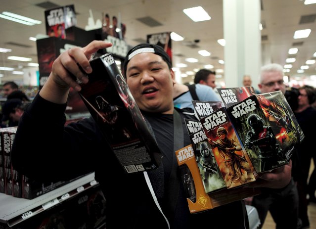 A shopper shows off his haul of new merchandise from the upcoming film “Star Wars: The Force Awakens” at a department store open just after midnight on “Force Friday” in Sydney, September 4, 2015. (Photo by Jason Reed/Reuters)