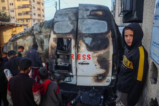 Children check the site of an Israeli strike on a broadcast truck, in the Nuseirat refugee camp in the central Gaza Strip, on December 26, 2024. A Palestinian TV channel affiliated with the militant group Islamic Jihad said five of its journalists were killed on December 26, in an Israeli strike on their vehicle, with Israel's military saying it had targeted a “terrorist cell”. A missile hit the journalists' broadcast truck as it was parked in the Nuseirat camp in central Gaza, according to a statement from their employer, Al-Quds Today. (Photo by Eyad Baba/AFP Photo)