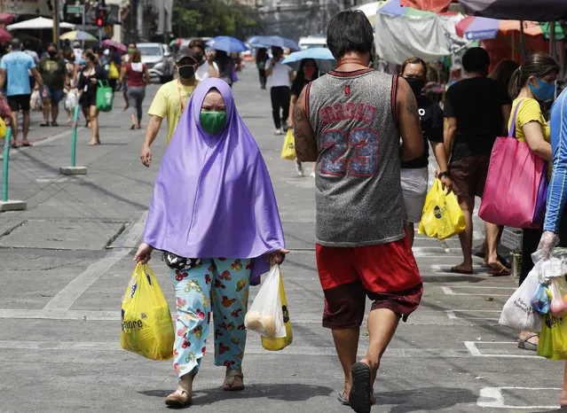 A Muslim woman wears a protective mask as she goes to a public market during an enhanced community quarantine to prevent the spread of the new coronavirus in Manila, Philippines on Thursday April 23, 20200. (Photo by Aaron Favila/AP Photo)
