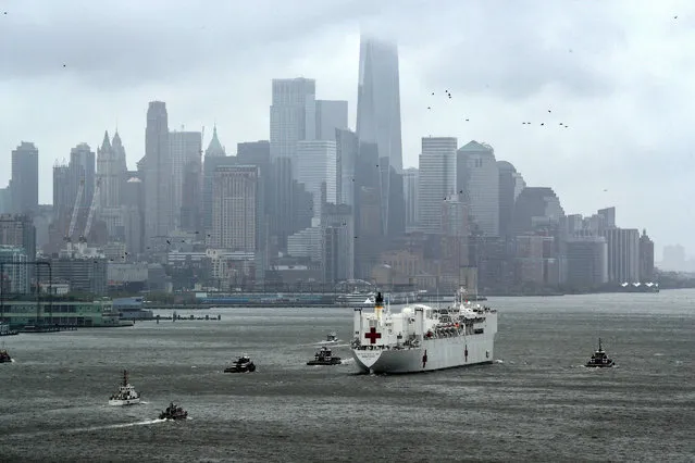 The U.S. Navy hospital ship USNS Comfort heads past lower Manhattan and the World Trade Center building under heavy fog as it leaves to return to its home port of Norfolk, Virginia, after treating patients during the outbreak of coronavirus disease (COVID-19) in New York City New York, U.S., April 30, 2020. (Photo by Mike Segar/Reuters)
