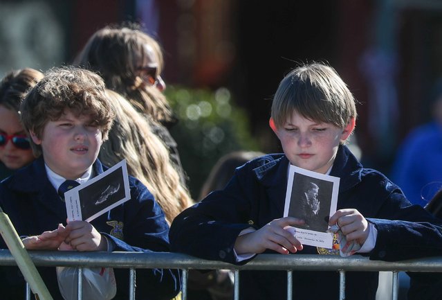 Students from Sumter County Middle School look at a remembrance card of former President Jimmy Carter as they await the arrival of Carter's funeral procession in his hometown of Plains, Georgia on January 9, 2025. (Photo by USA Today)